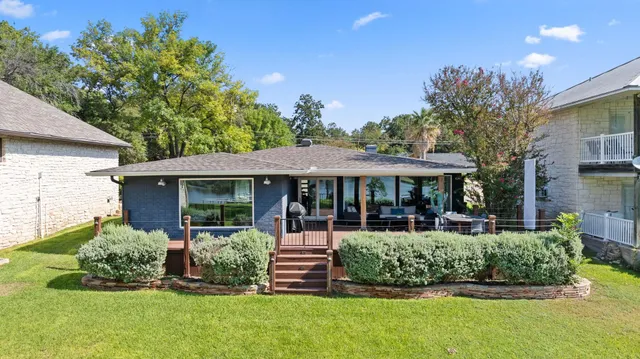 an aerial view of a houses with a yard and lake view