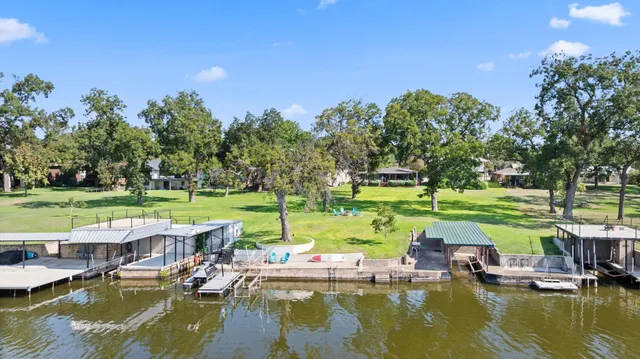 an aerial view of residential houses with outdoor space and lake view