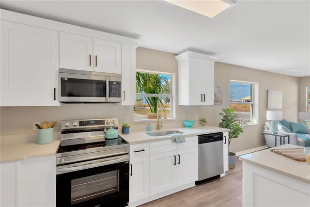 a kitchen with cabinets appliances a sink and a counter top space