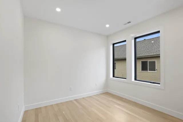a view of an empty room with closet and a window