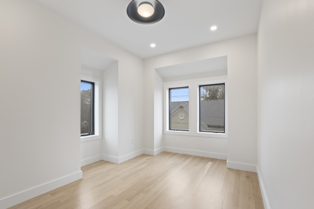 14 Bonair Street, Unit 14 Somerville, MA 02145 - Photo 20 of 39 an empty room with wooden floor and windows