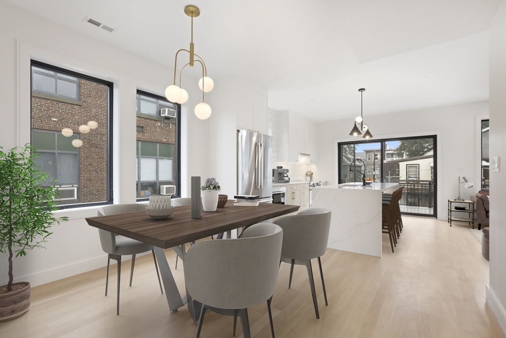 14 Bonair Street, Unit 14 Somerville, MA 02145 - Photo 2 of 39 a dining room with wooden floor a chandelier a wooden table and chairs