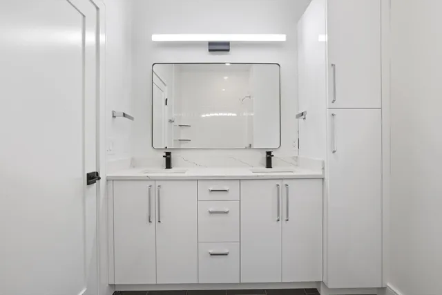 a close view of a sink a mirror and shower in the background