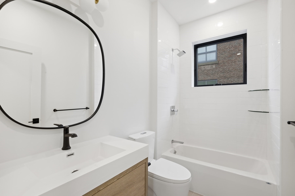 14 Bonair Street, Unit 14 Somerville, MA 02145 - Photo 10 of 39 a bathroom with a sink a mirror a toilet and a bathtub