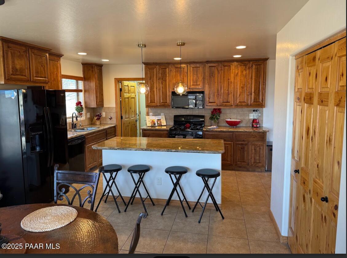 1740 West Bumblebee Road Chino Valley, AZ 86323 - Photo 9 of 44 a kitchen with stainless steel appliances a dining table chairs refrigerator and sink