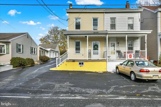 a view of a white house with swimming pool in front of it