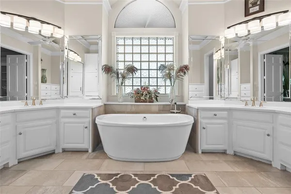 a spacious bathroom with a large tub sink and mirror