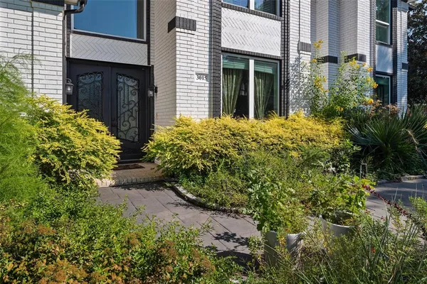 a view of house with garden and tall trees