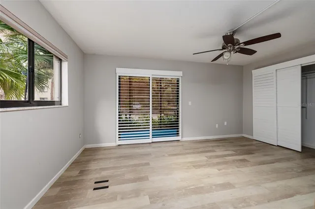 an empty room with windows and fan