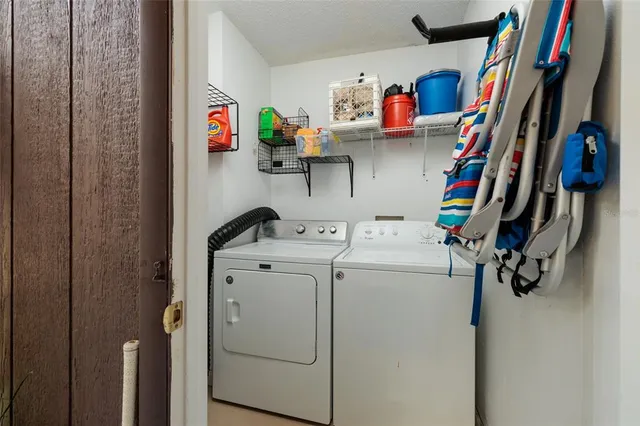 a view of storage and utility room with dryer and washer
