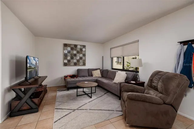 a living room with furniture and a flat screen tv with wooden floor