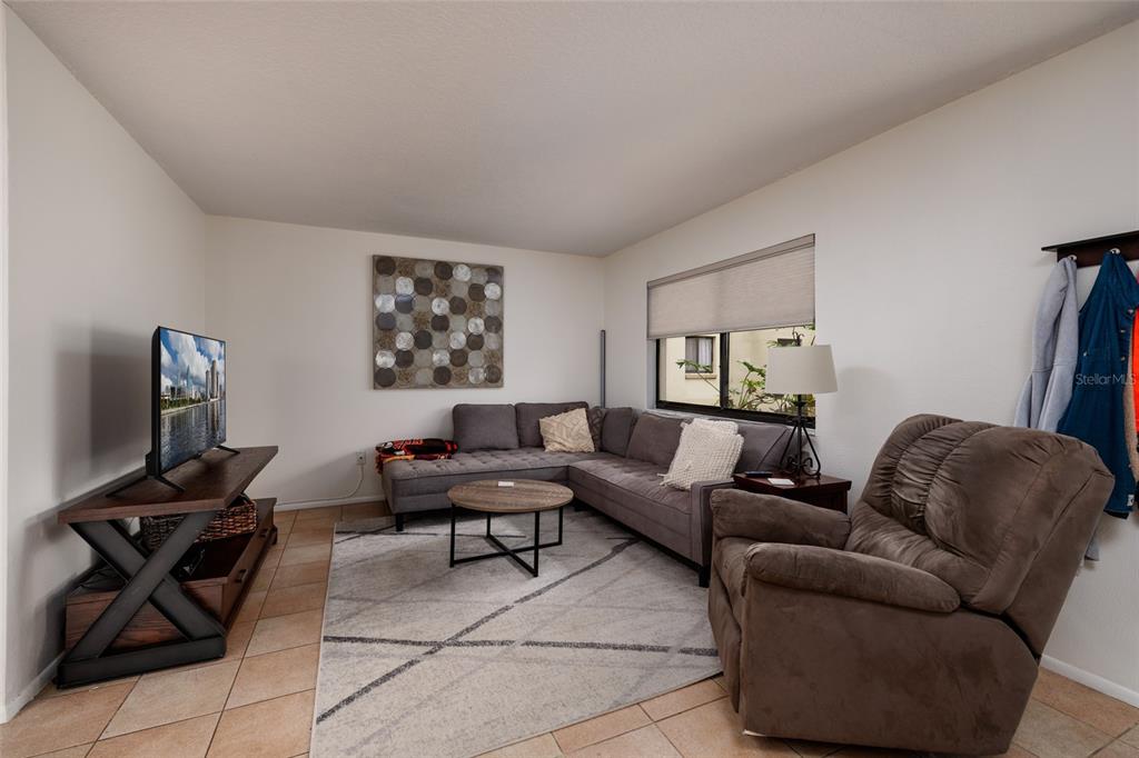 11708 Raintree Village Boulevard, Unit A Temple Terrace, FL 33617 - Photo 5 of 21 a living room with furniture and a flat screen tv with wooden floor