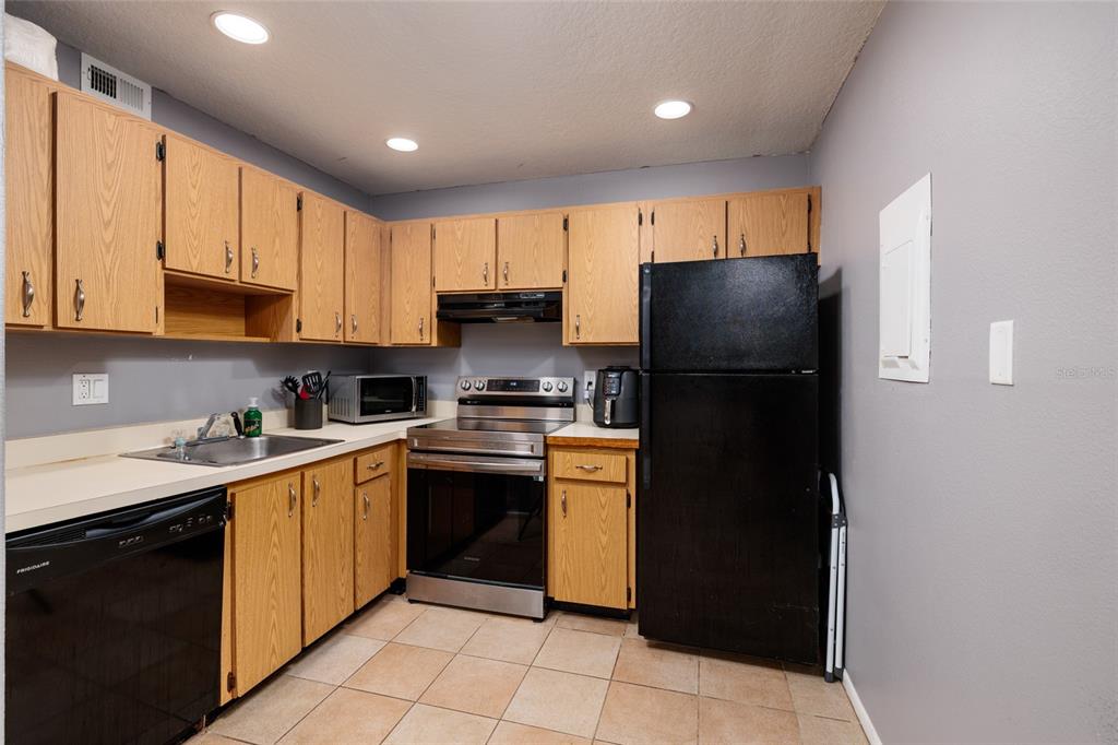 11708 Raintree Village Boulevard, Unit A Temple Terrace, FL 33617 - Photo 8 of 21 a kitchen with a refrigerator a stove top oven a sink and cabinets