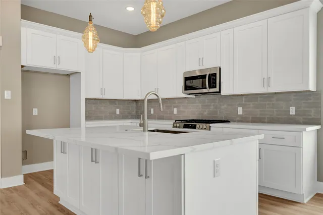 a view of a kitchen with wooden floor and a window