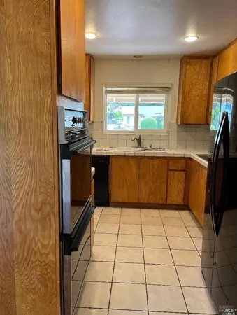 a kitchen with stainless steel appliances a sink a stove top oven a counter space and cabinets