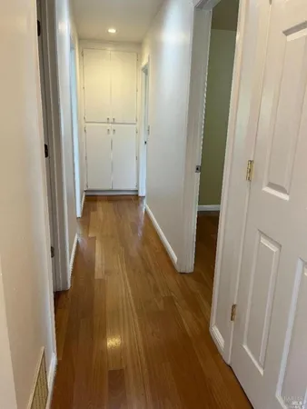 a view of a hallway with wooden floor