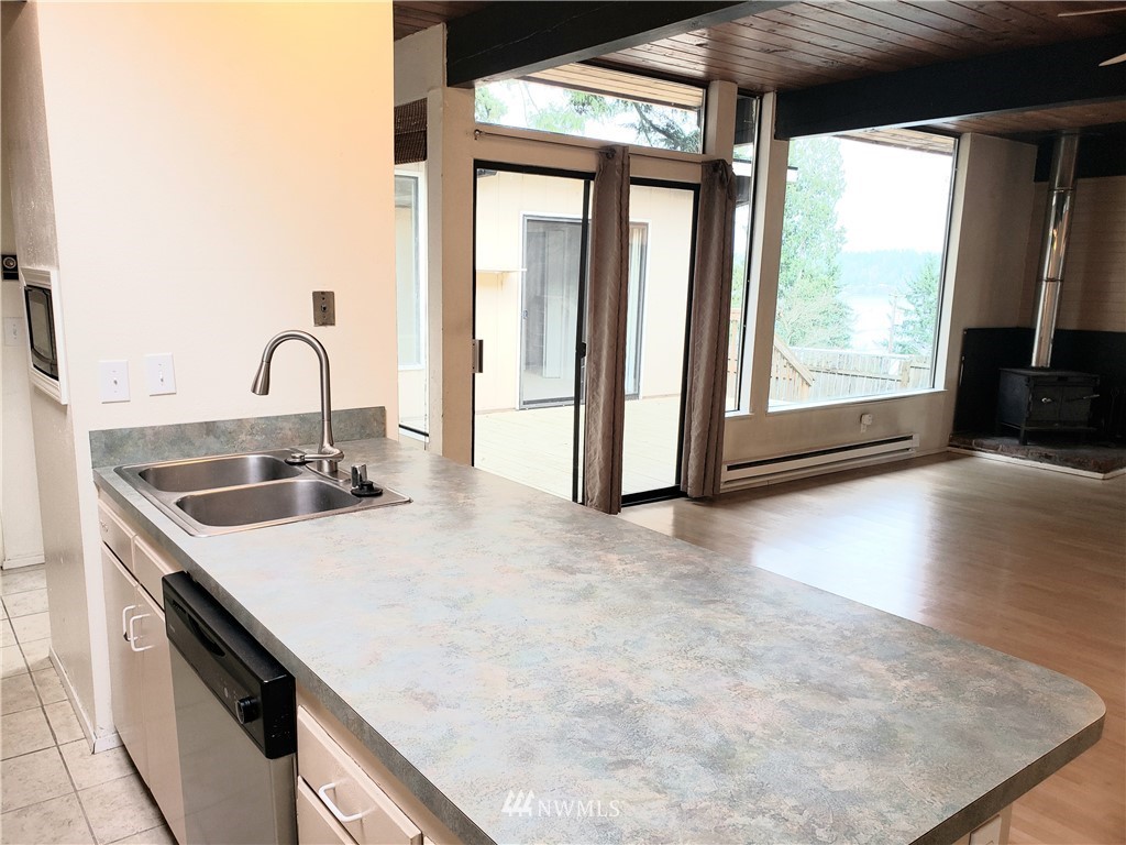 8690 Illahee Road Northeast Bremerton, WA 98311 - Photo 24 of 40 a kitchen with stainless steel appliances granite countertop a sink a stove and a wooden floors