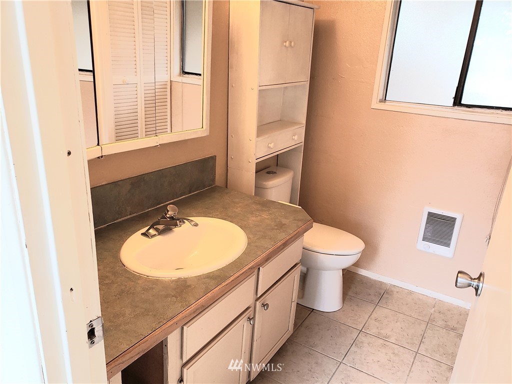 8690 Illahee Road Northeast Bremerton, WA 98311 - Photo 30 of 40 a bathroom with a granite countertop sink toilet and mirror