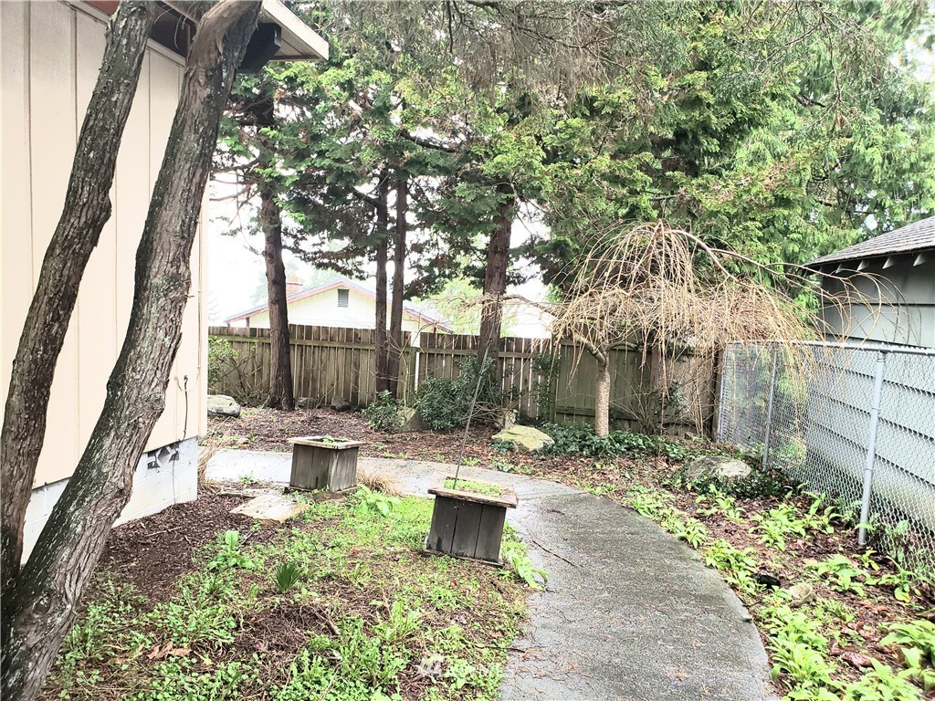 8690 Illahee Road Northeast Bremerton, WA 98311 - Photo 9 of 40 a view of a patio with table and chairs potted plants and large tree