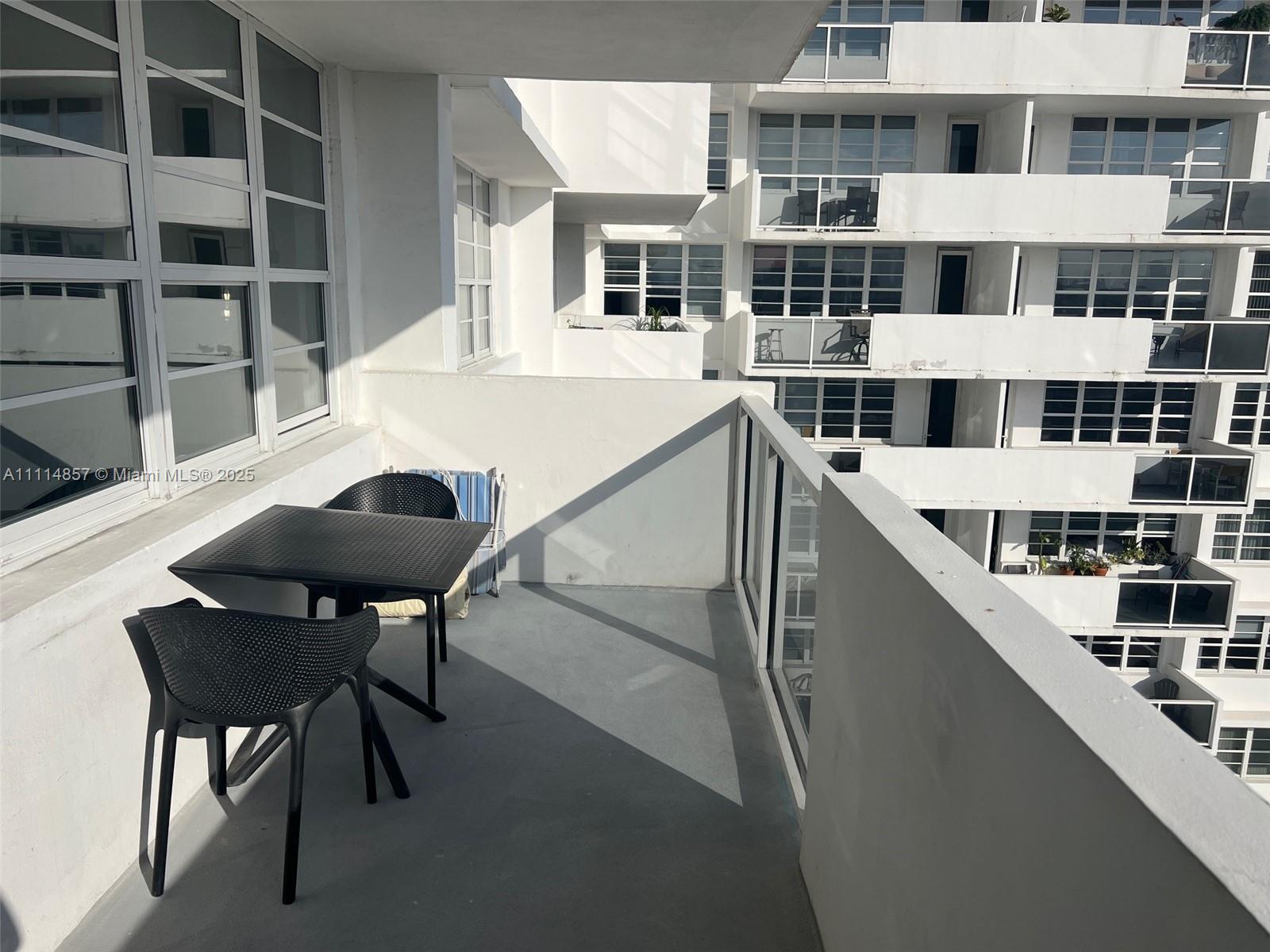 100 Lincoln Road, Unit 1207 Miami Beach, FL 33139 - Photo 3 of 54 a view of a balcony with table and chairs