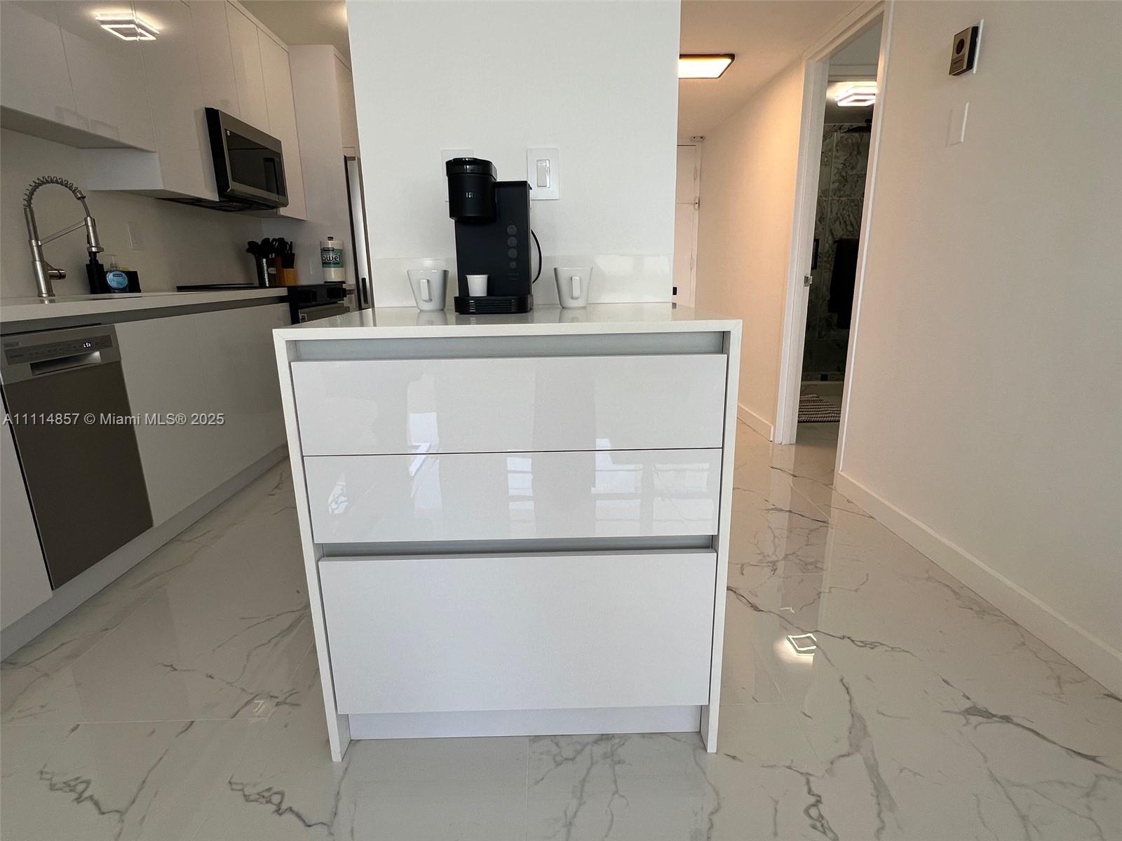 100 Lincoln Road, Unit 1207 Miami Beach, FL 33139 - Photo 9 of 54 a kitchen with a sink and a refrigerator