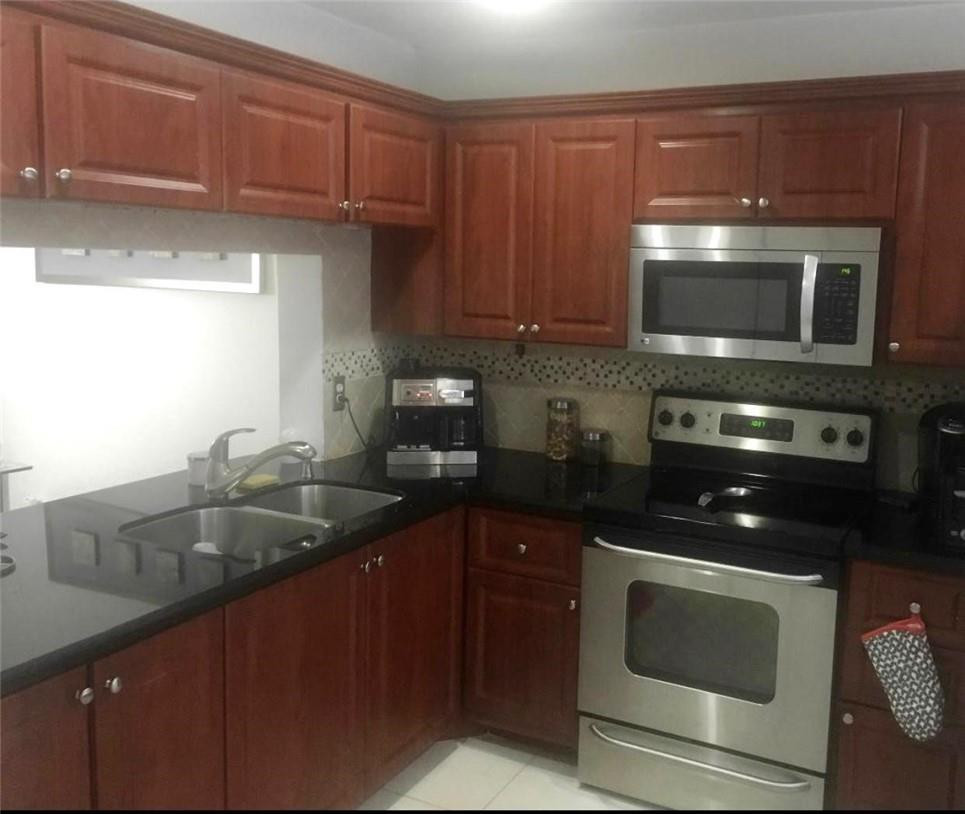 10932 West Sample Road, Unit F2 Coral Springs, FL 33065 - Photo 21 of 23 a kitchen with a sink and cabinets