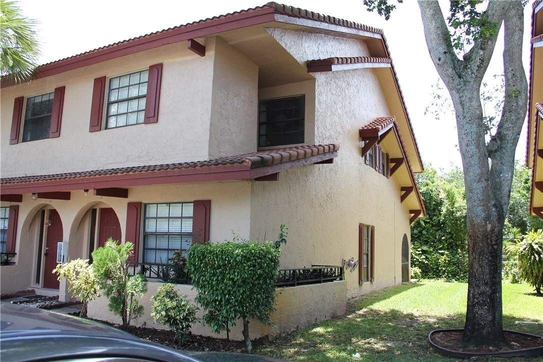 10932 West Sample Road, Unit F2 Coral Springs, FL 33065 - Photo 3 of 23 a front view of a house with garden