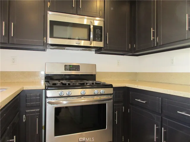 a kitchen with granite countertop cabinets stainless steel appliances and wooden floor