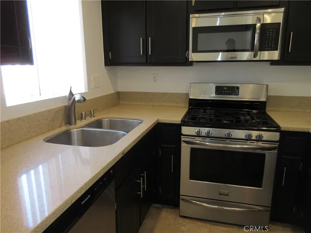 a kitchen with granite countertop a stove and a sink