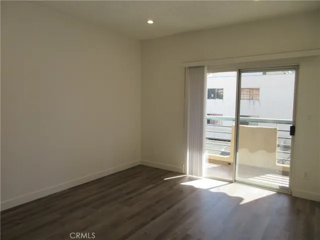 an empty room with wooden floor and door