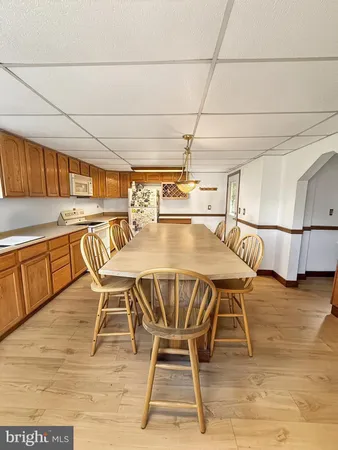 a dining area with stainless steel appliances granite countertop a table chairs and granite counter tops