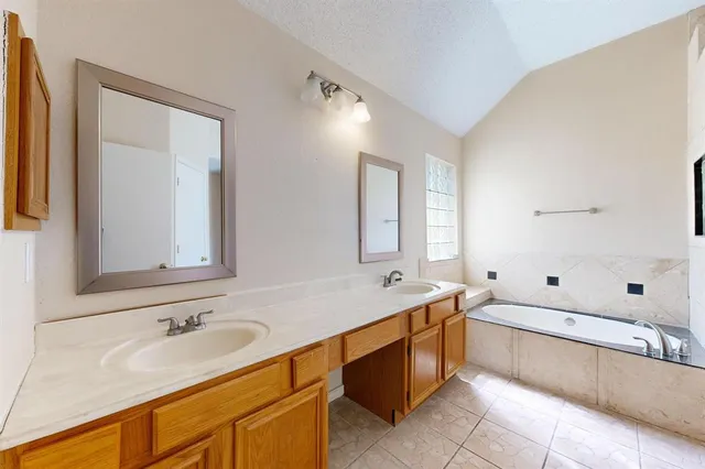a bathroom with a tub sink and mirror