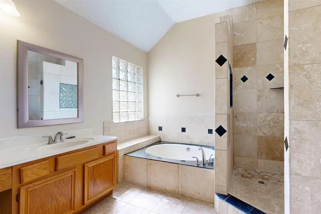a bathroom with a granite countertop tub sink and mirror