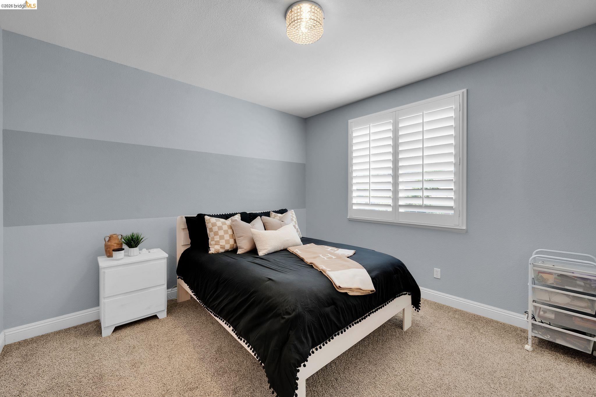 2513 Winged Foot Road Brentwood, CA 94513 - Photo 24 of 45 Carpeted interior space featuring a window with white louvered shutters, a flush-mount ceiling light fixture, and two-tone wall paint