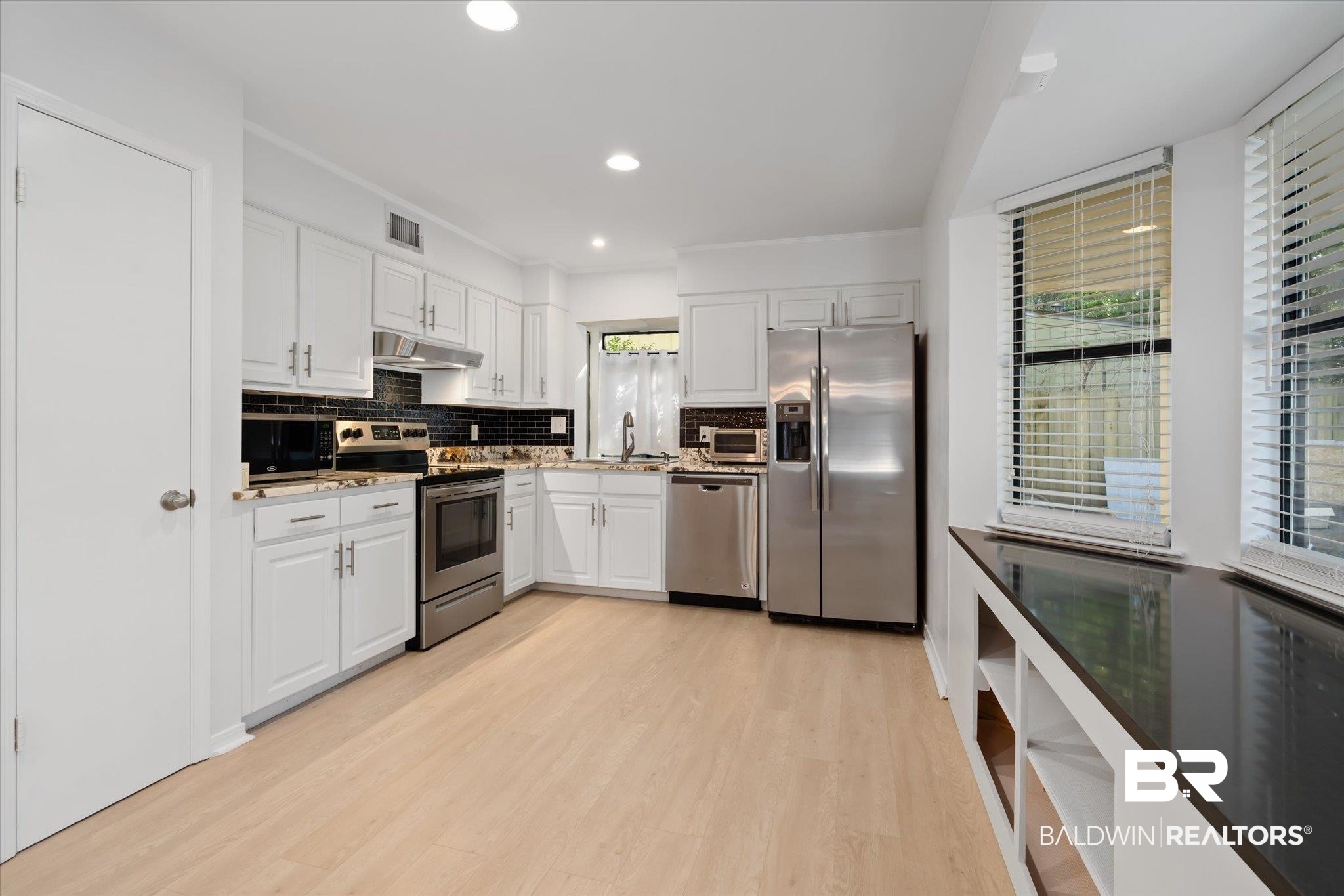 1008 Mcneil Avenue Mobile, AL 36609 - Photo 6 of 20 Kitchen with white cabinets, sink, stainless steel appliances, and tasteful backsplash