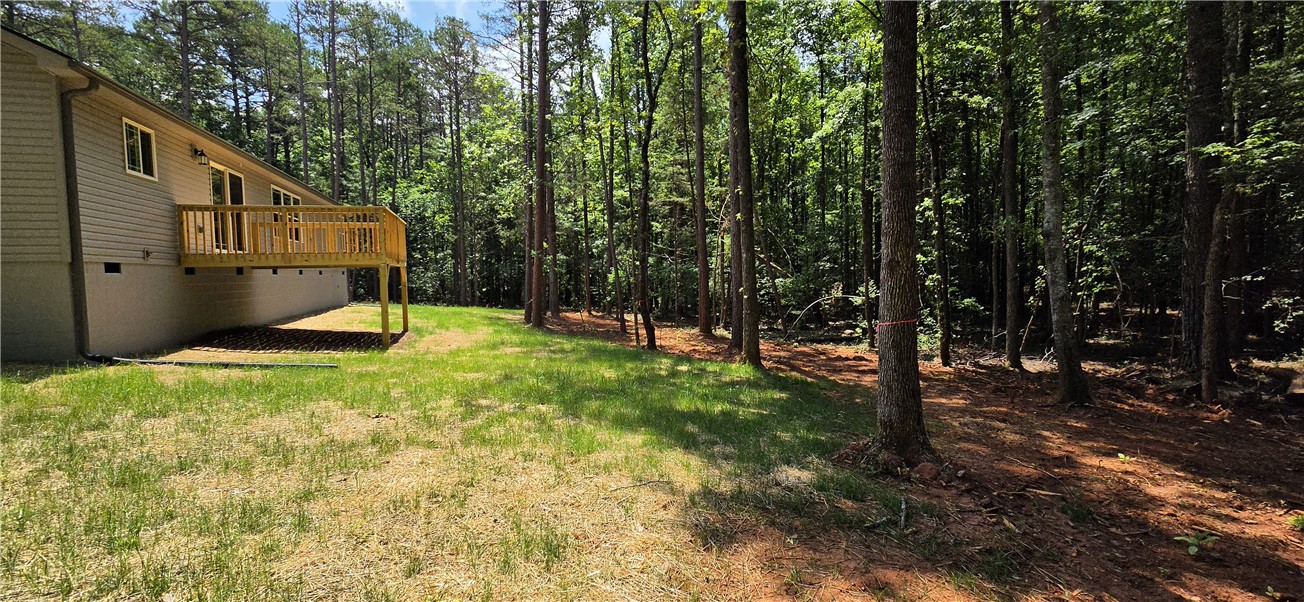 1747 A State Rd S-4-97 Anderson, SC 29621 - Photo 38 of 47 A private, natural setting with a spacious outdoor deck, surrounded by a verdant forest.