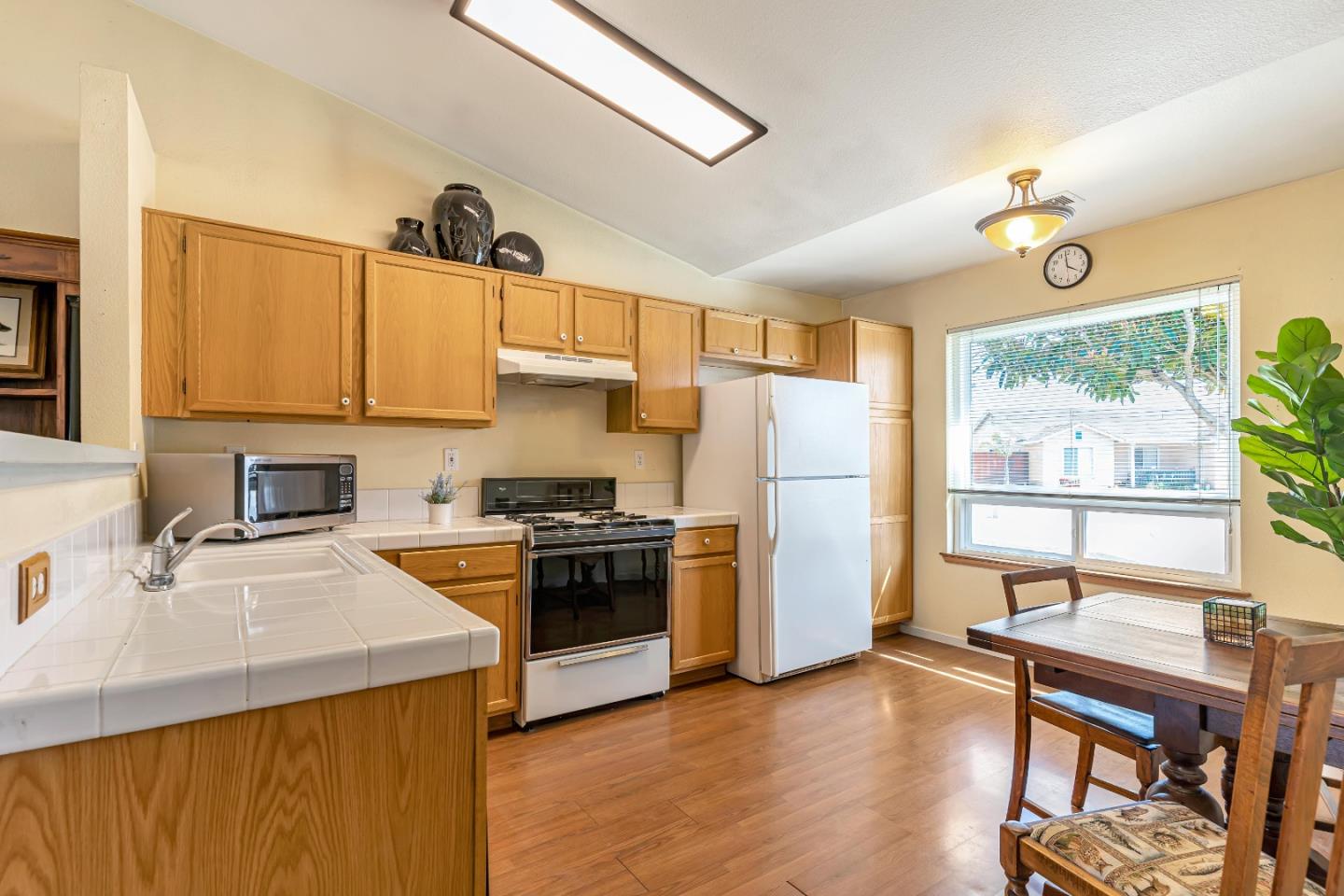 440 Meyer Circle Gonzales, CA 93926 - Photo 13 of 45 a kitchen with stainless steel appliances granite countertop a refrigerator a sink dishwasher a stove and a dining table with wooden floor