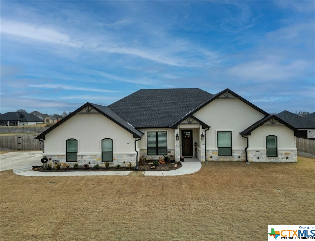 a view of house with yard and sitting area