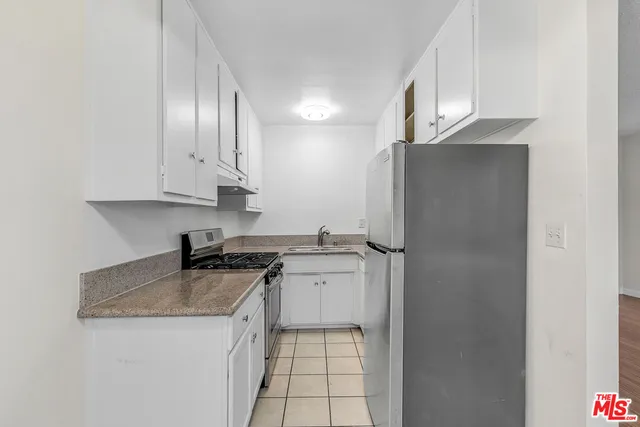 a kitchen with stainless steel appliances granite countertop a stove a refrigerator and a sink