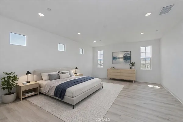 a bedroom with a bed and a potted plant on dresser
