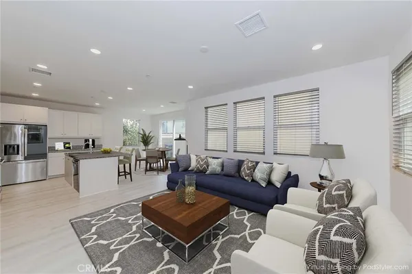 a living room with furniture and view of kitchen