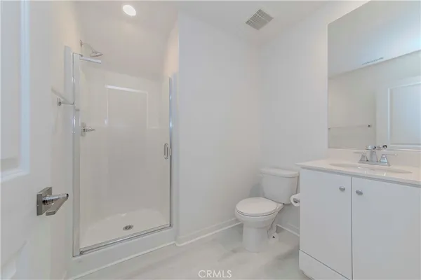 a bathroom with a granite countertop sink a toilet and shower