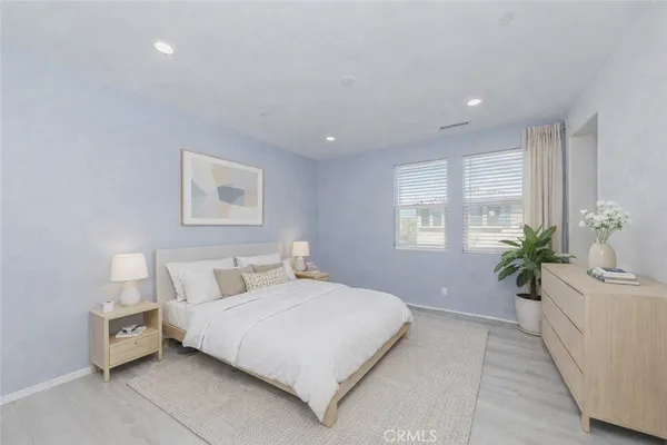 a bedroom with a large bed and a potted plant