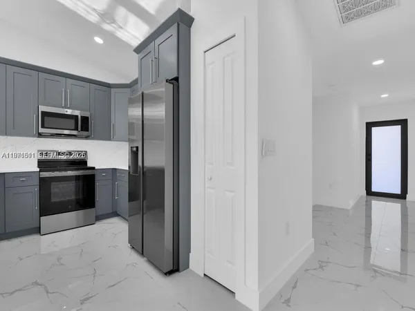 a kitchen with stainless steel appliances a refrigerator and a stove top oven