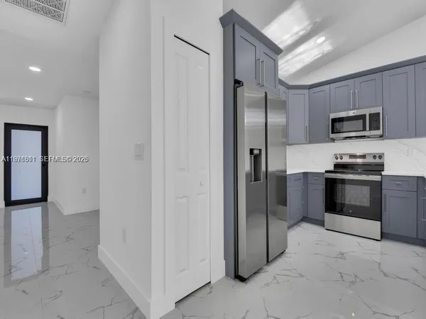 a kitchen with granite countertop a refrigerator and a sink