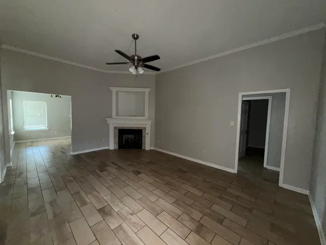 an empty room with windows and fireplace