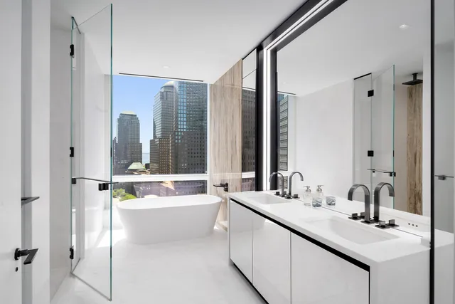 a bathroom with a double vanity sink a mirror and a bathtub