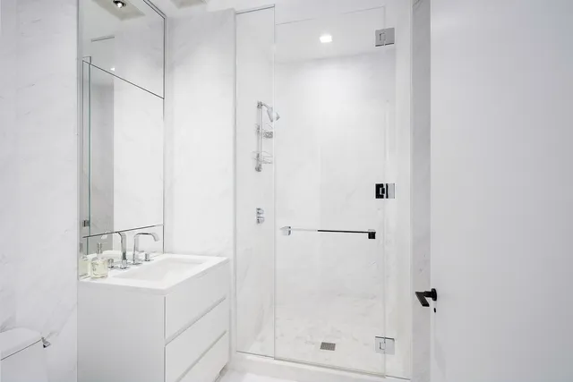 a bathroom with a shower sink vanity and mirror