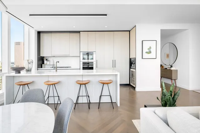 a kitchen with stainless steel appliances kitchen island granite countertop a sink a stove a dining table and chairs