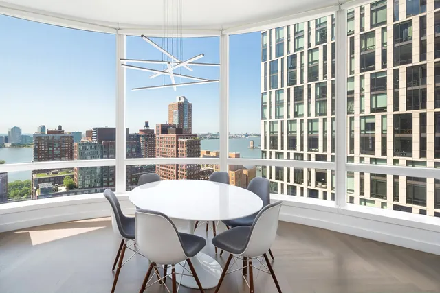a dining room with furniture and a floor to ceiling window